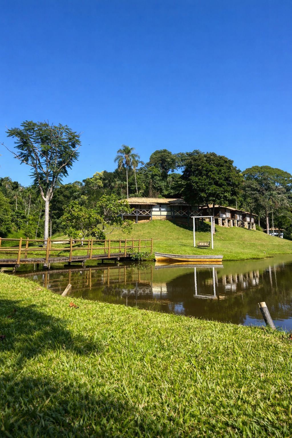 Vista panorâmica do Hotel Fazenda Bom Retiro com lago e chalés cercados pela natureza